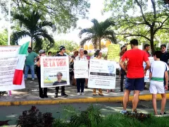 Manifestantes con pancartas que critican las medidas preventivas impuestas por las autoridades sanitarias, Mérida, Yucatán.