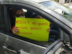 Maestra dentro de automóvil con cartel protesta por regreso a clases presenciales. Fotografía: Juan Manuel Contreras.