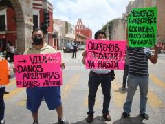 Empleados manifestándose por la reapertura de bares y restaurantes con cartulinas. Fotografía: Gabriel Chan.