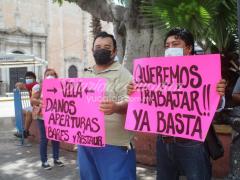 Empleados manifestándose por la reapertura de bares y restaurantes con cartulinas. Fotografía: Gabriel Chan.